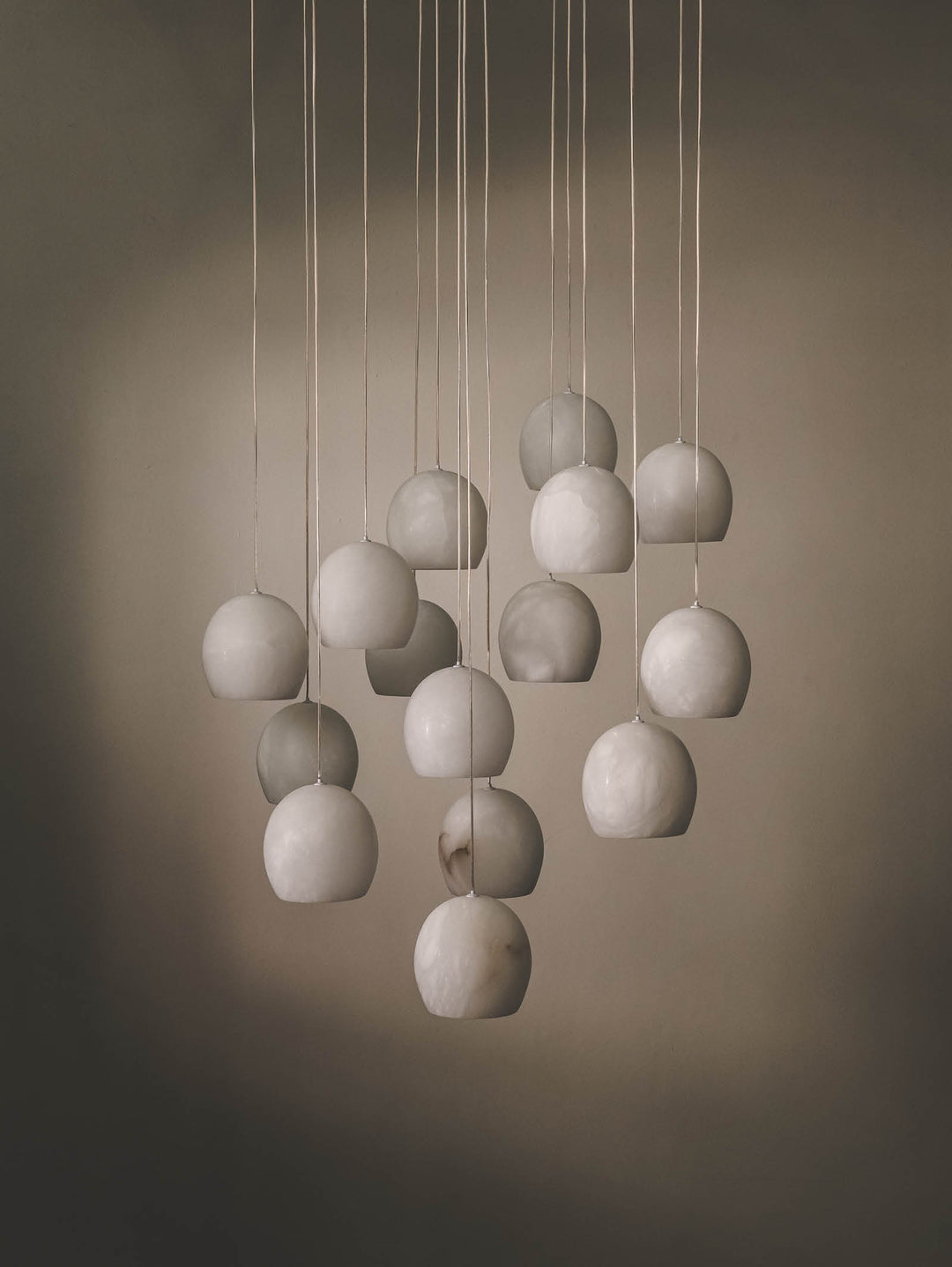 15-bulb multi pendant with alabaster shade and stainless-steel frame.