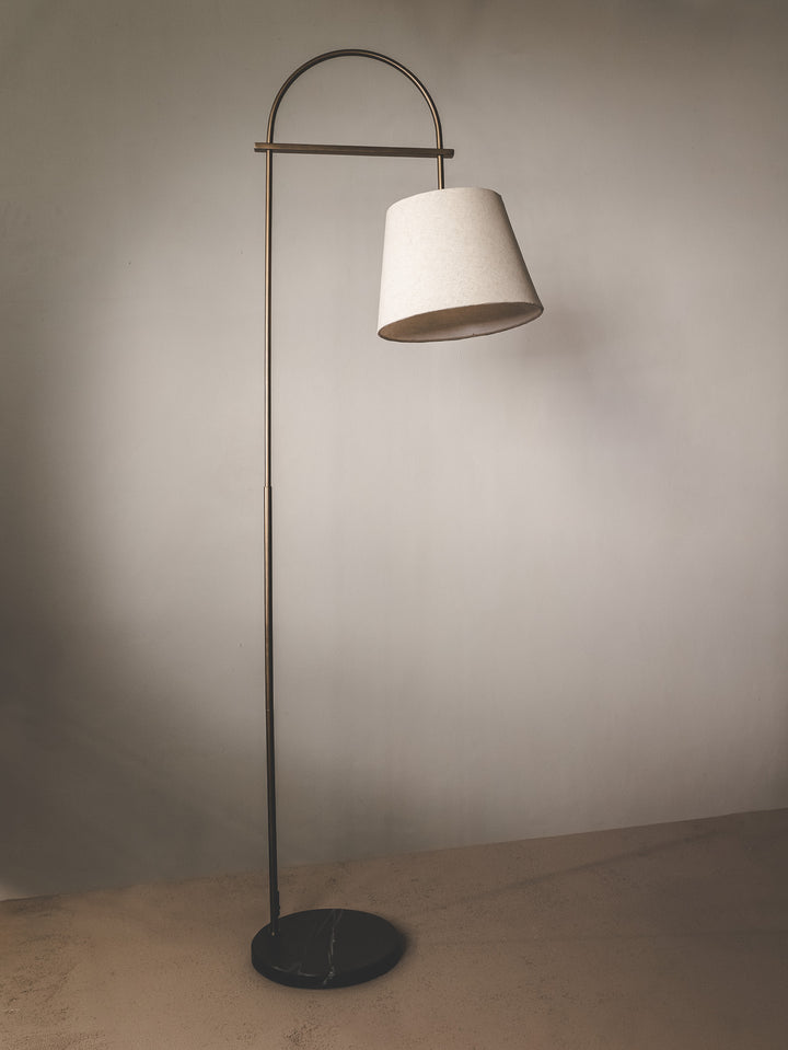 Floor lamp with slender steel support, brass detail and linen shade.