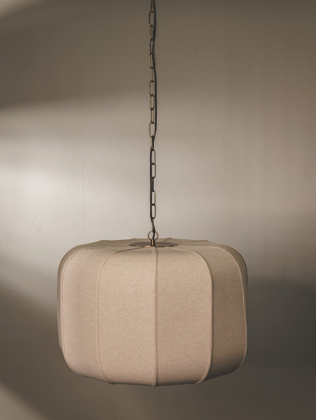 Pendant light with hand-stitched linen lampshade and steel composition.