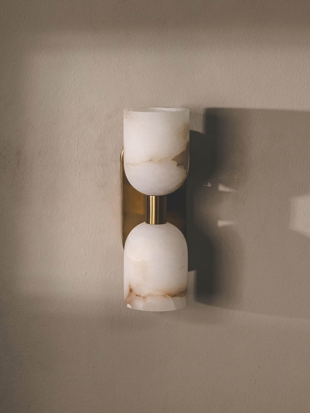 Handmade wall light with twin alabaster shades and stainless-steel support.
