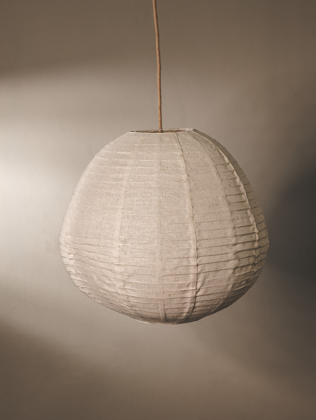 Linen fabric covered lantern pendant with foldable design in natural colourway.
