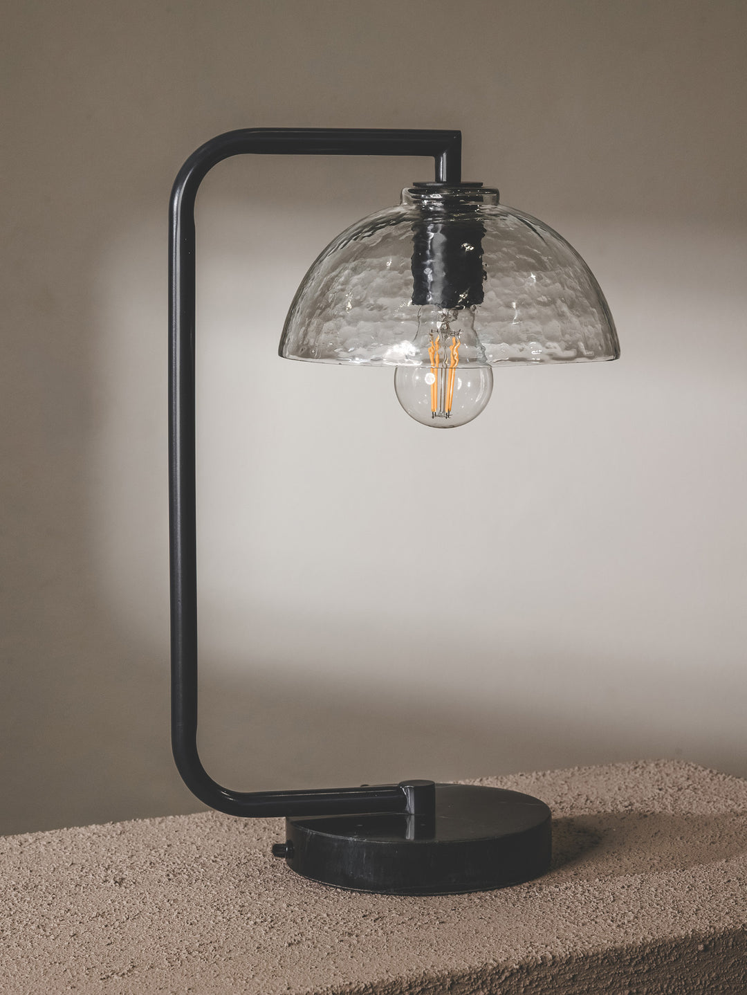 Chic desk lamp with steel frame, glass shade and marble base in black colourway.