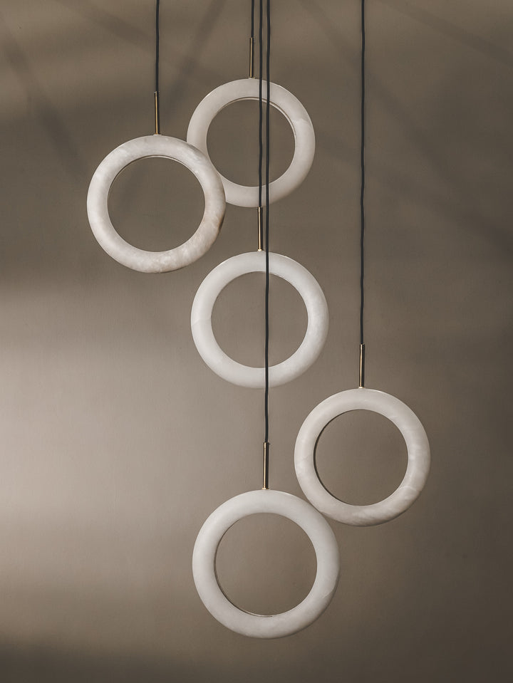 Multi-pendant that features light rings made from alabaster marble with arresting modern design.
