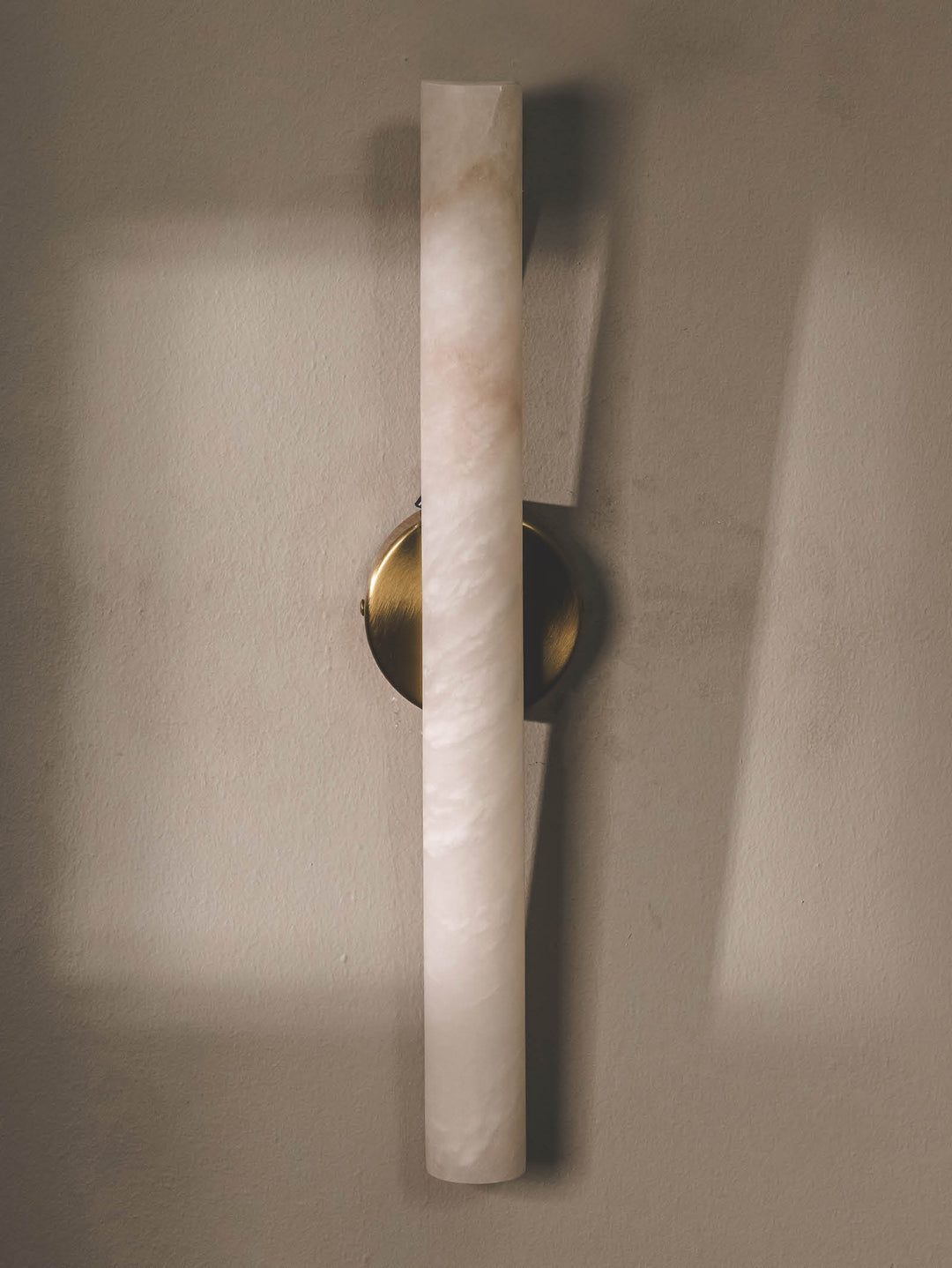 Handmade cylindrical light made of alabaster and sturdy stainless-steel frame.