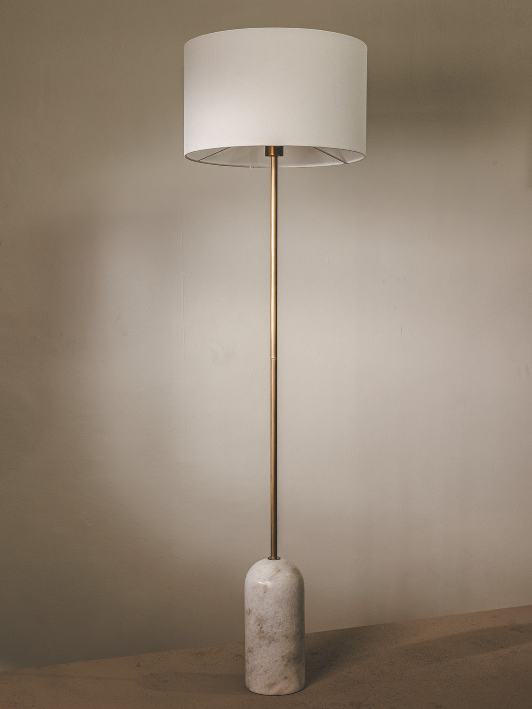 Marble floor lamp with fabric shade and brass fixtures.